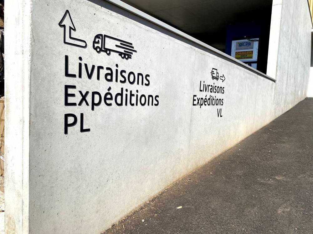 Signalétique extérieure lettres en plexiglass découpées au laser et contre collé directement sur mur en béton